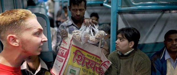A foreigner looking at peanuts in Indian train.